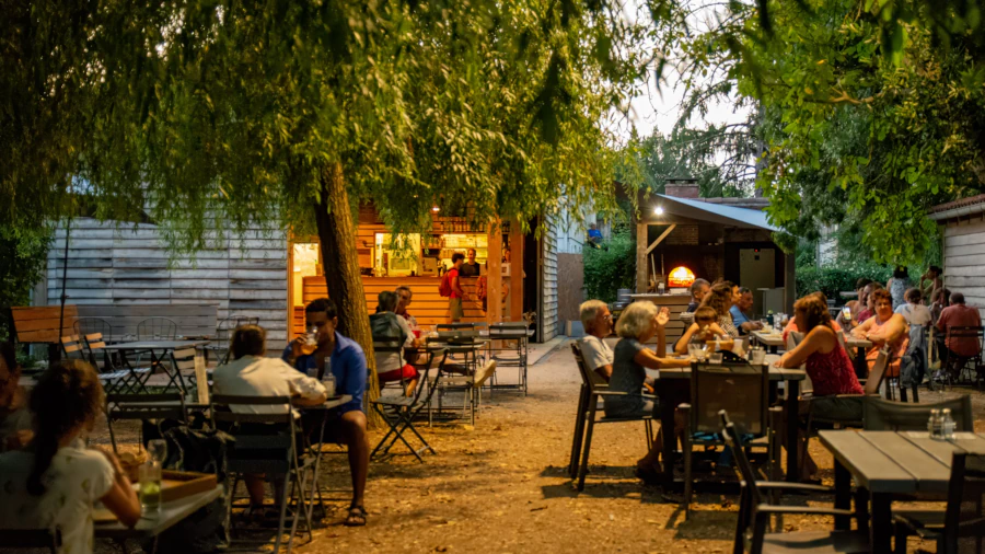 Aperçu du restaurant et du four à bois dans une petite pénombre avec quelques clients attablés