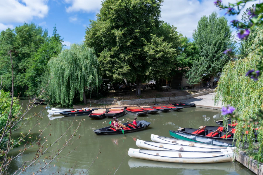 Photo du site avec en premier plan les bateaux et les canoés puis le restaurant en arrière plan