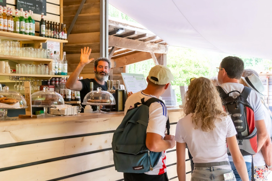 Gérant derrière son bar saluant le photographe
